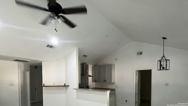 kitchen featuring ceiling fan, sink, wall chimney exhaust hood, kitchen peninsula, and vaulted ceiling