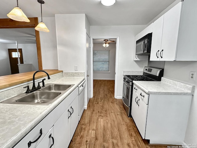 kitchen with gas range, ceiling fan, sink, pendant lighting, and white cabinetry