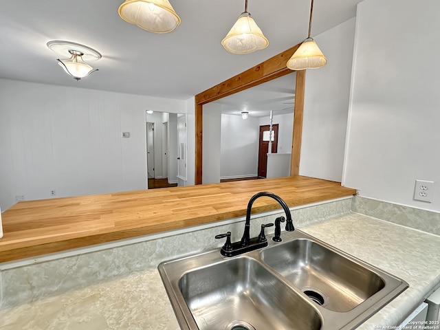 kitchen featuring butcher block counters, sink, and pendant lighting