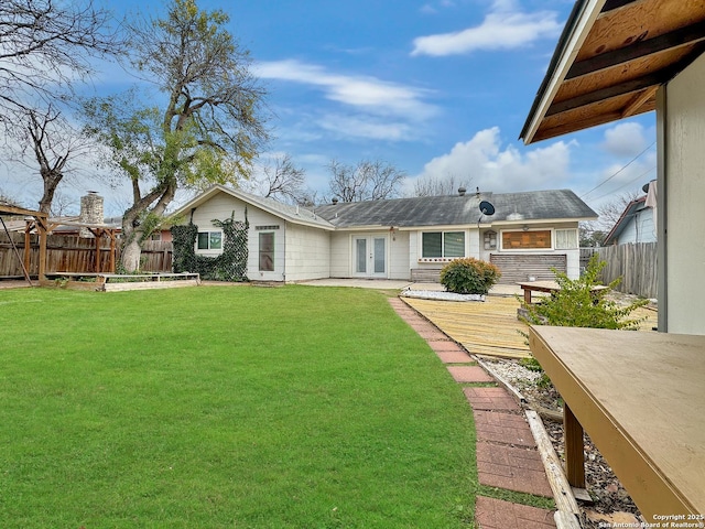 back of house with french doors, a yard, and a deck