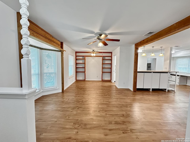 unfurnished living room featuring hardwood / wood-style floors, plenty of natural light, and ceiling fan