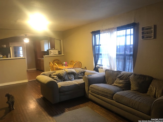 living room with ceiling fan and dark hardwood / wood-style flooring