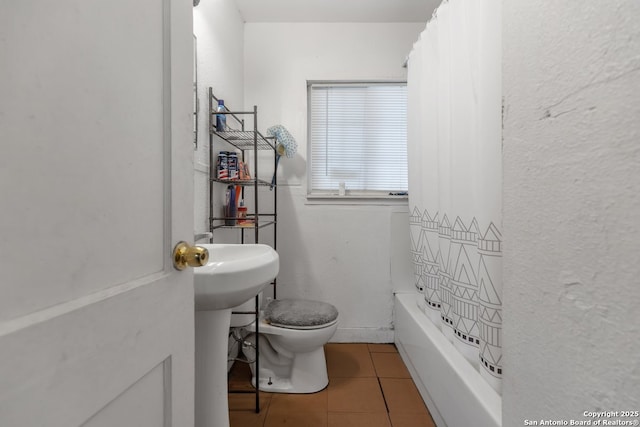 bathroom with shower / bath combination with curtain, tile patterned floors, and toilet