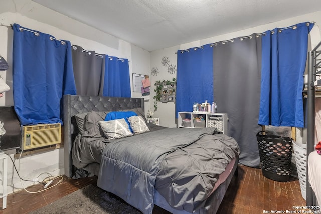 bedroom with hardwood / wood-style flooring, cooling unit, and a textured ceiling