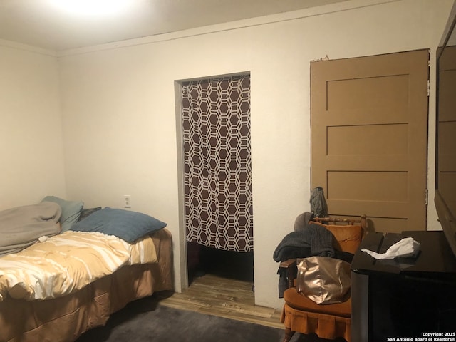 bedroom with crown molding and hardwood / wood-style floors