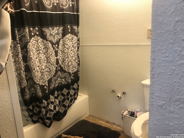 bathroom with hardwood / wood-style floors, toilet, and shower / bath combo