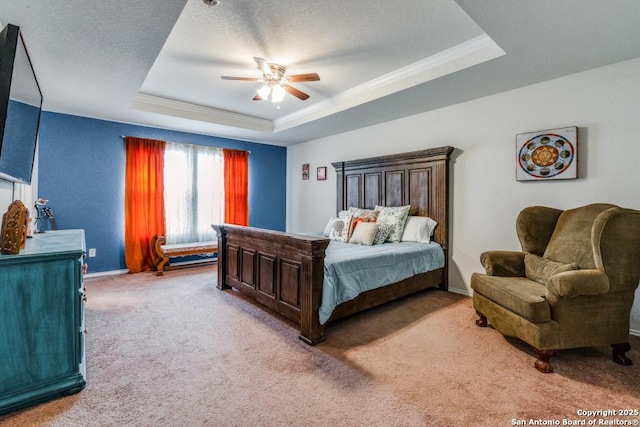 carpeted bedroom featuring a textured ceiling, a raised ceiling, ceiling fan, and ornamental molding