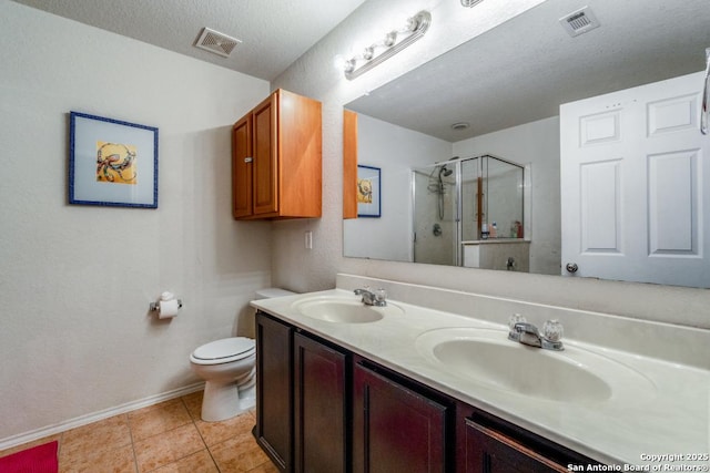 bathroom with tile patterned floors, an enclosed shower, vanity, a textured ceiling, and toilet