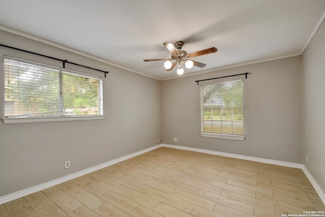 empty room featuring crown molding, ceiling fan, and a healthy amount of sunlight