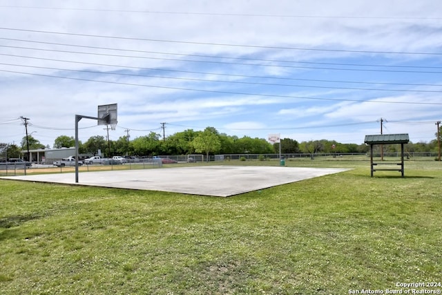 view of sport court featuring a yard, community basketball court, and fence