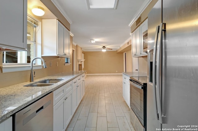 kitchen featuring light stone countertops, sink, ceiling fan, stainless steel appliances, and white cabinets