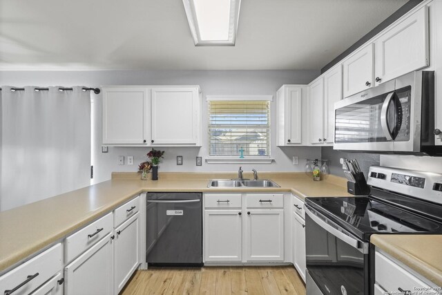 kitchen featuring appliances with stainless steel finishes, white cabinetry, and sink