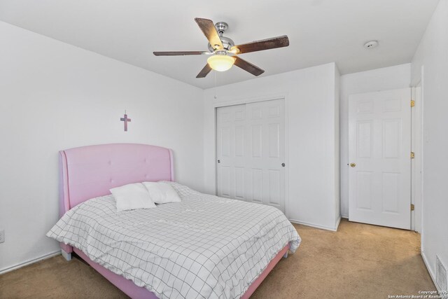 carpeted bedroom with ceiling fan and a closet