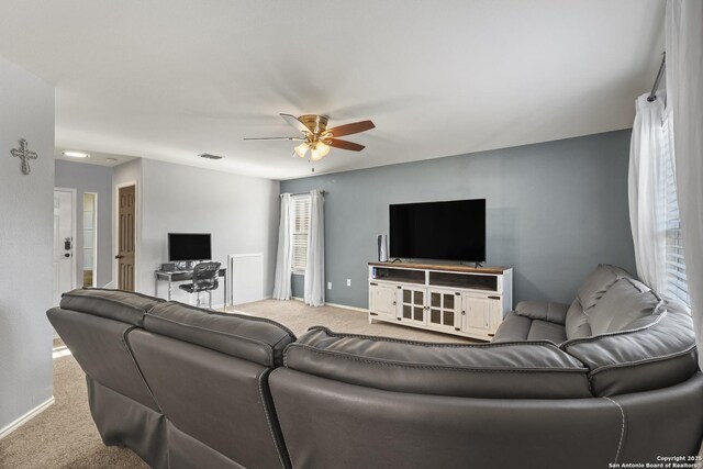 carpeted living room with ceiling fan