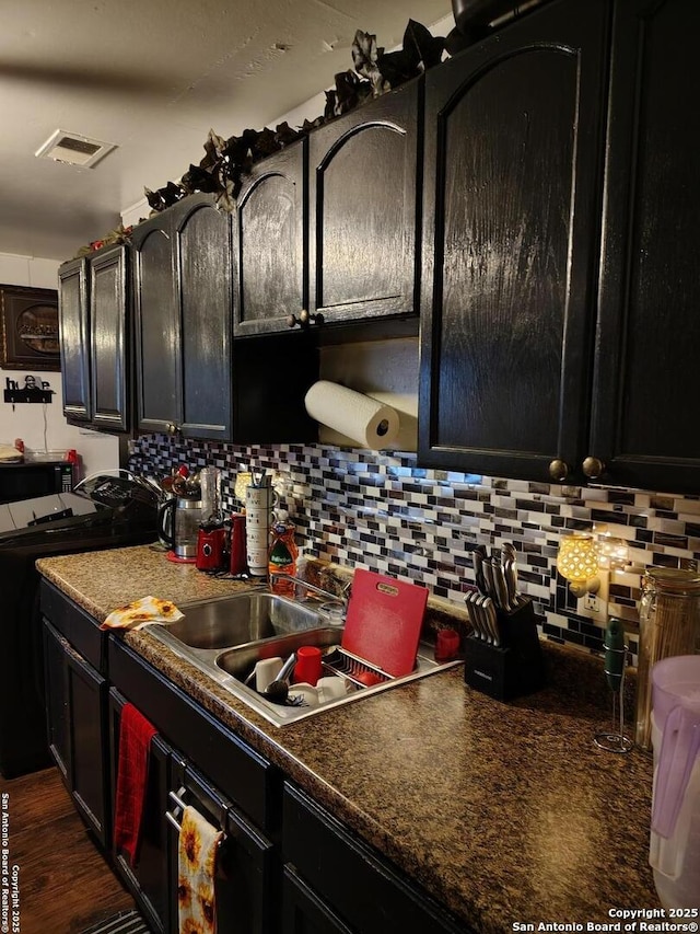 kitchen with tasteful backsplash, dark hardwood / wood-style floors, washer / dryer, and electric range oven