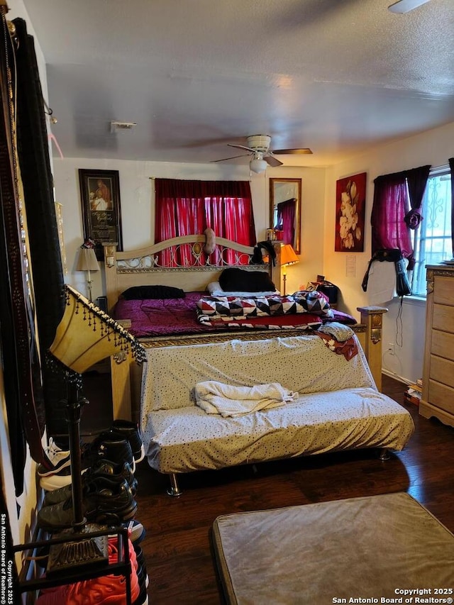 bedroom featuring a textured ceiling, ceiling fan, and dark wood-type flooring