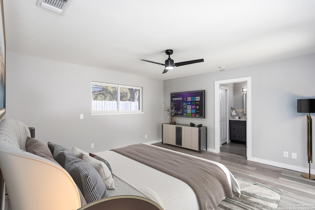 bedroom featuring connected bathroom, light hardwood / wood-style floors, and ceiling fan