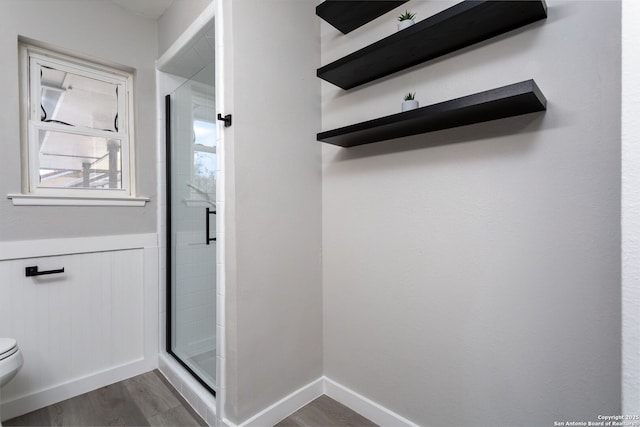 bathroom featuring toilet, hardwood / wood-style floors, and walk in shower