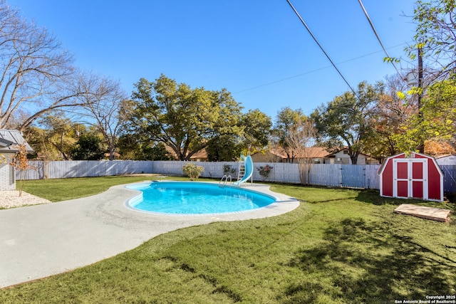 view of swimming pool featuring a shed, a lawn, and a water slide