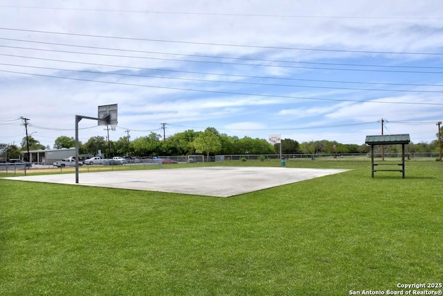 view of sport court with a lawn