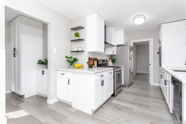 kitchen with dishwasher, wall chimney exhaust hood, light hardwood / wood-style floors, white cabinetry, and stainless steel range with gas stovetop