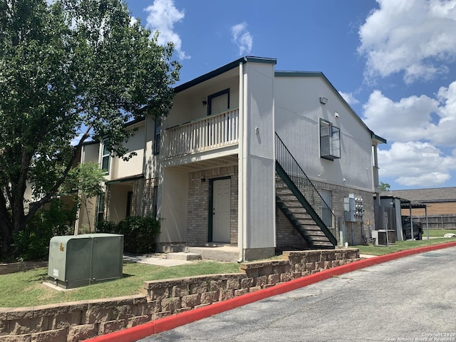 view of front of house featuring a balcony and central AC unit