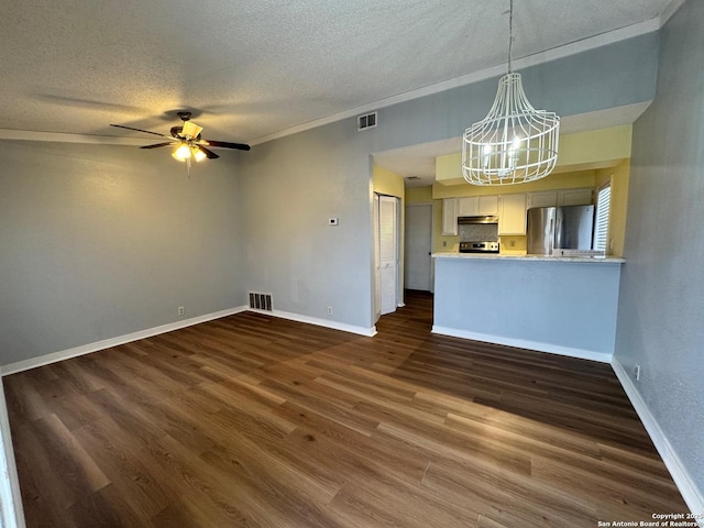 unfurnished living room featuring ceiling fan with notable chandelier, dark hardwood / wood-style flooring, and a textured ceiling