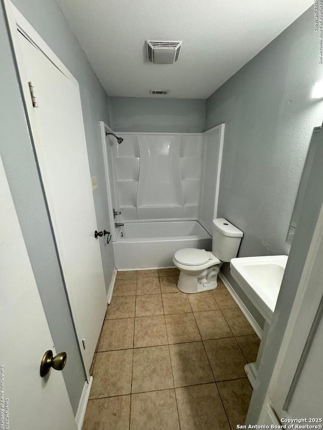 bathroom featuring tile patterned flooring, shower / bathtub combination, and toilet