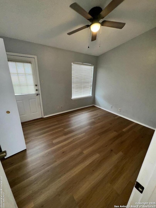 spare room featuring ceiling fan and dark hardwood / wood-style floors