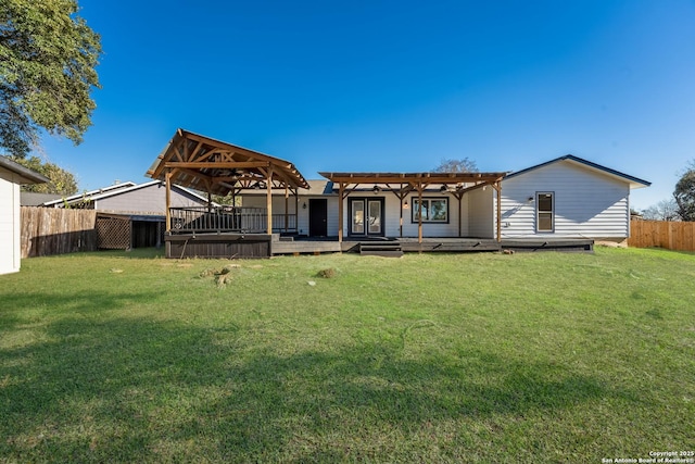 rear view of property with a yard, a pergola, and a deck