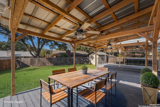 deck featuring ceiling fan, a yard, and a storage unit