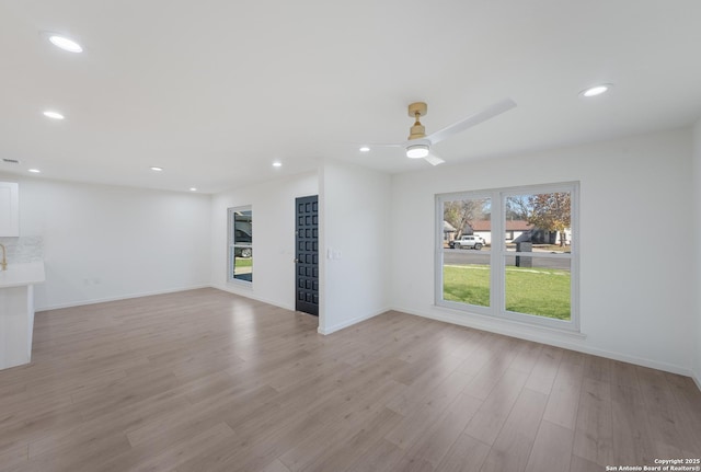 unfurnished living room with ceiling fan and light hardwood / wood-style floors