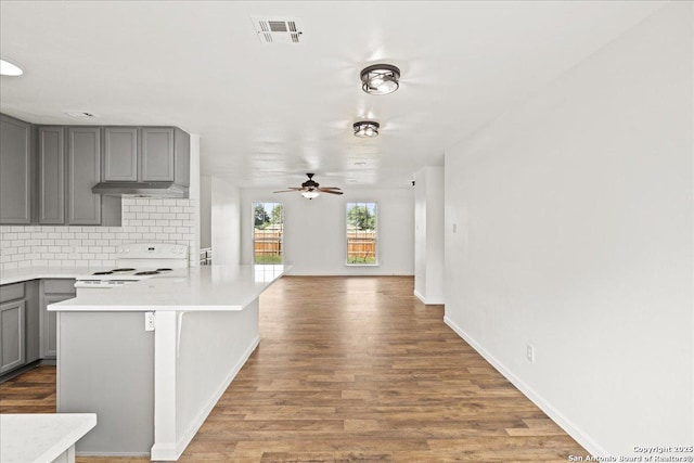 kitchen featuring backsplash, ceiling fan, gray cabinets, and white electric stove