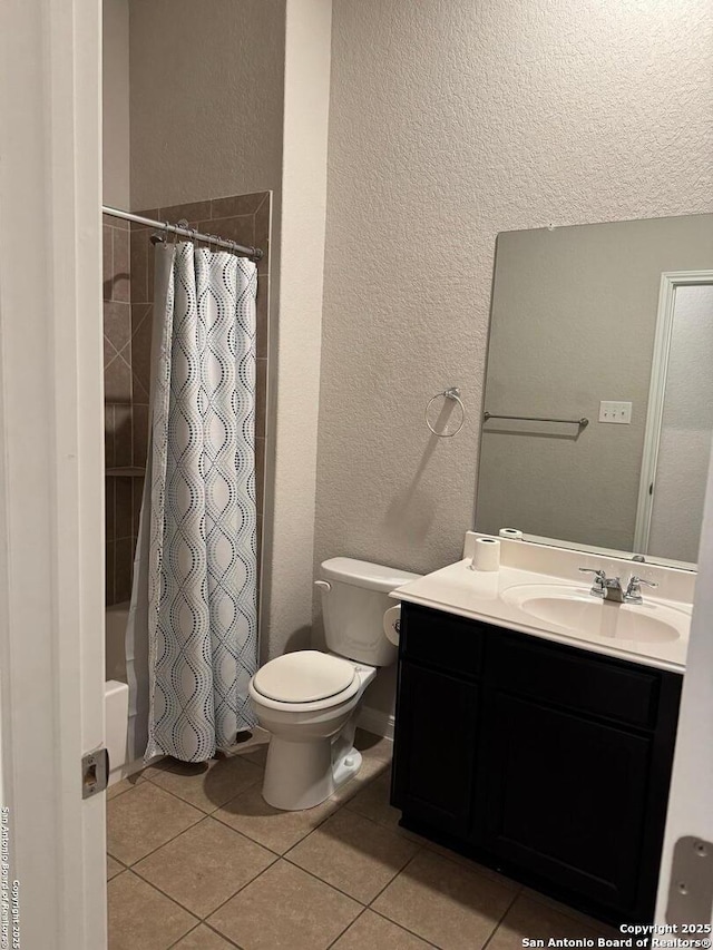 full bath featuring tile patterned flooring, shower / tub combo with curtain, vanity, and toilet