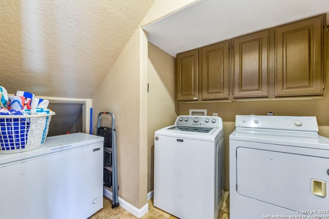 clothes washing area featuring washing machine and dryer and cabinets