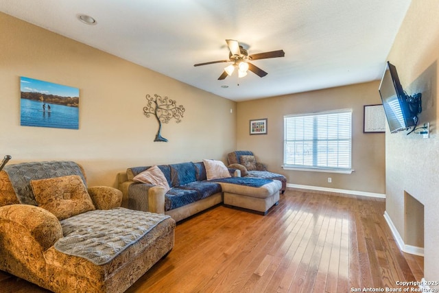 living room with wood-type flooring and ceiling fan