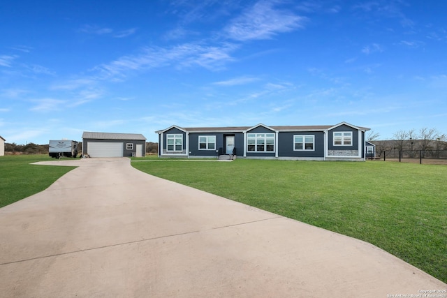 ranch-style house with a front yard, an outbuilding, and a garage