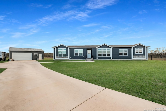 view of front facade featuring an outbuilding, a front lawn, and a garage