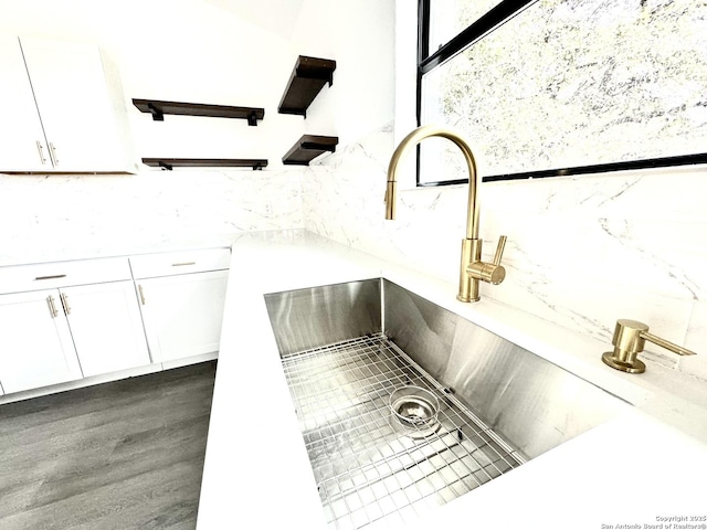 room details featuring white cabinets and sink