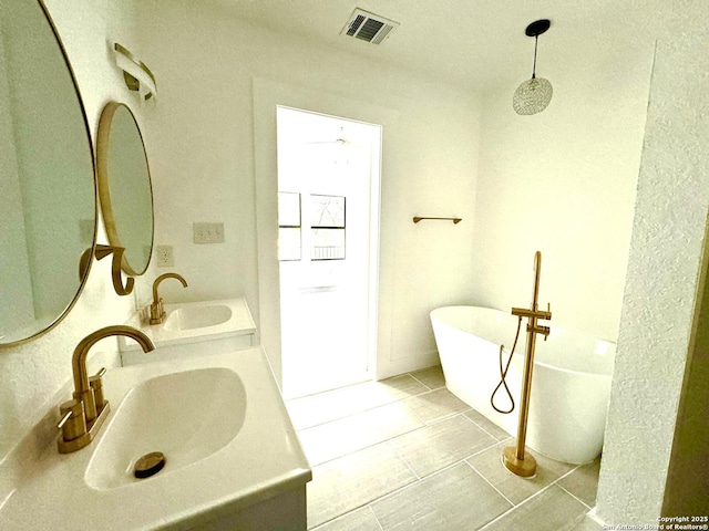 bathroom featuring a bathing tub, vanity, and tile patterned floors