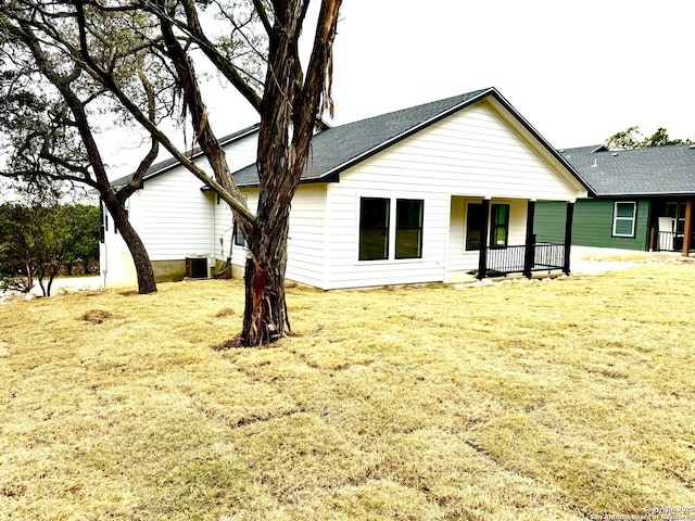 rear view of house with a lawn and a porch