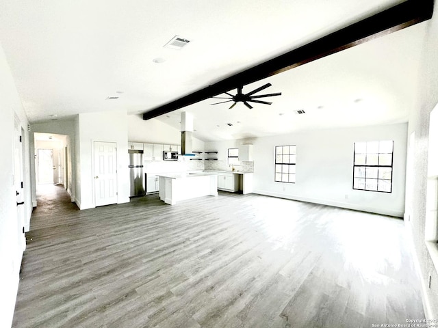 unfurnished living room with vaulted ceiling with beams, hardwood / wood-style flooring, and ceiling fan