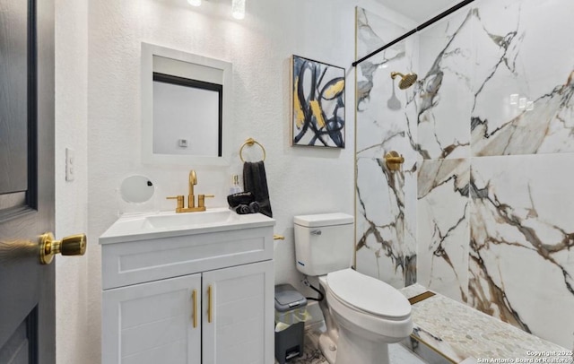 bathroom with vanity, toilet, and a shower