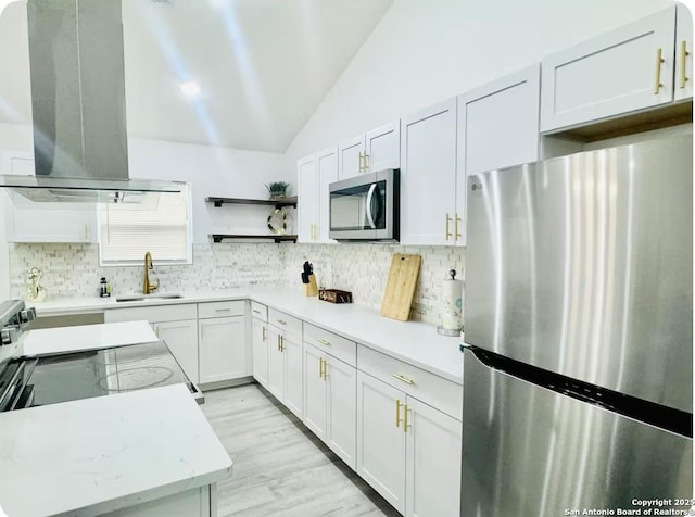 kitchen with ventilation hood, stainless steel appliances, sink, white cabinets, and lofted ceiling