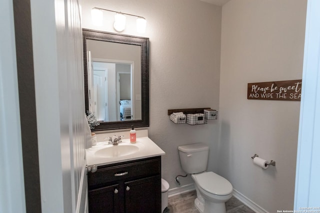 bathroom with vanity, toilet, and wood-type flooring