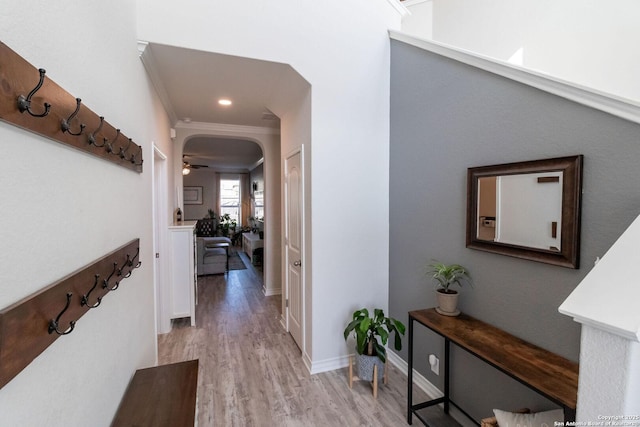 hall featuring ornamental molding and light hardwood / wood-style floors