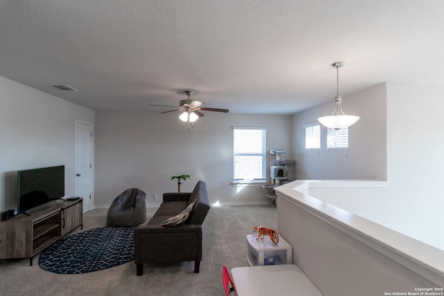 carpeted living room featuring a textured ceiling and ceiling fan