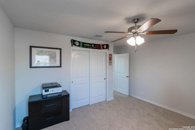 bedroom featuring ceiling fan, a closet, and light carpet