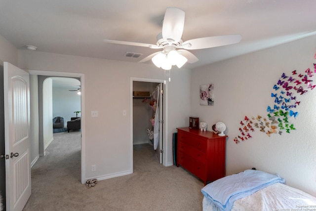 carpeted bedroom featuring ceiling fan, a spacious closet, and a closet