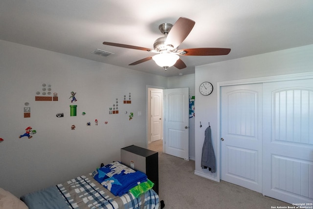 unfurnished bedroom with light carpet, ceiling fan, and a closet